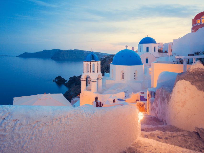 voyager en couple au coucher de soleil sur les toits bleus d' Oia-Santorin- Cyclades